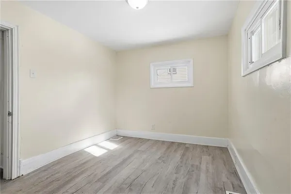 a view of empty room with wooden floor