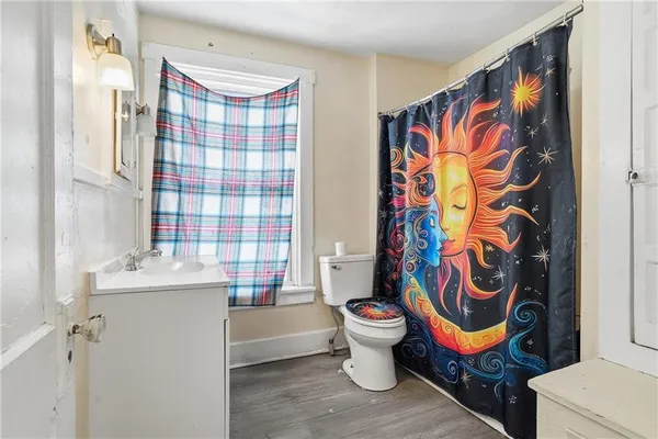 a bathroom with a sink toilet and shower curtain