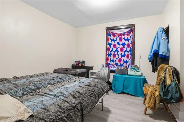 a bedroom with a bed and a painting on the wall