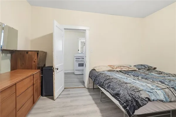 a bedroom with a bed and a refrigerator