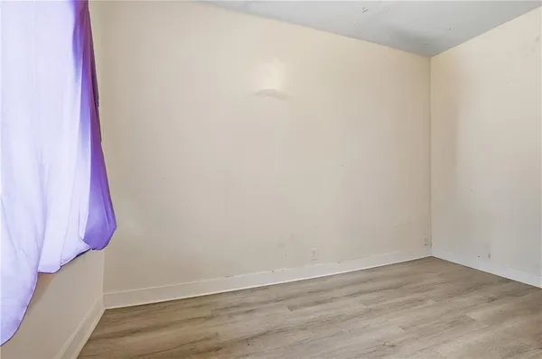 a view of a room with wooden floor and a wall