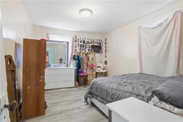 a bedroom with a bed and a refrigerator