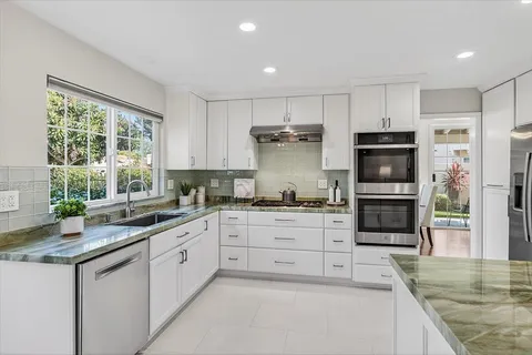 a kitchen with stainless steel appliances granite countertop a stove and a sink