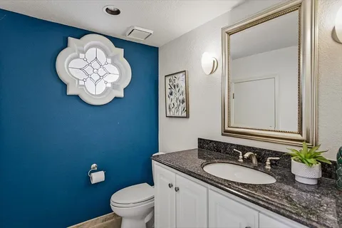 a bathroom with a granite countertop sink and a mirror