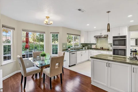 a kitchen with a table chairs microwave and cabinets