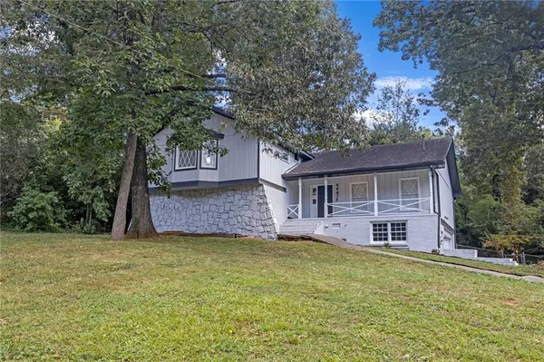a front view of a house with yard and trees