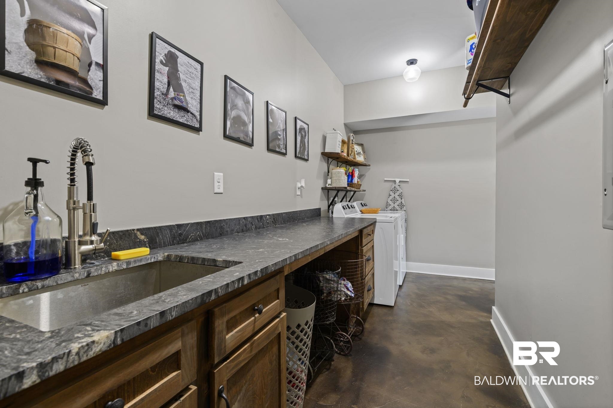 11025 Creax Road Axis, AL 36505 - Photo 19 of 45 Utility room featuring an elongated countertop with an undermount sink and a pull-down faucet, wood-finish cabinetry, concrete-finish flooring, and open shelving