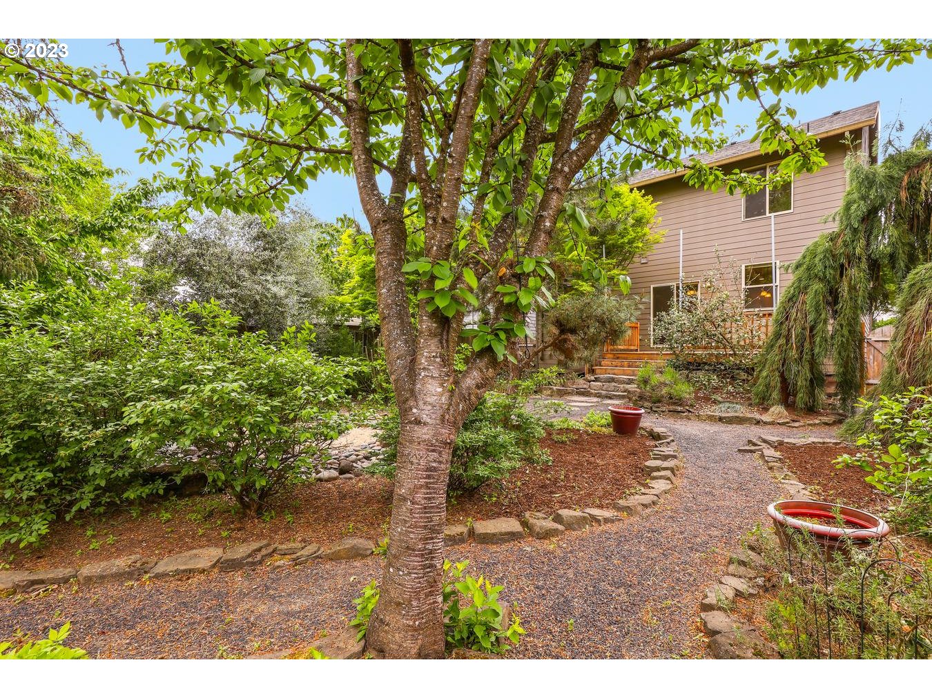 9277 Southwest Rambler Lane Portland, OR 97223 - Photo 32 of 38 a view of a yard with plants and a bench