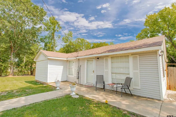 a view of a chair and table in backyard of the house