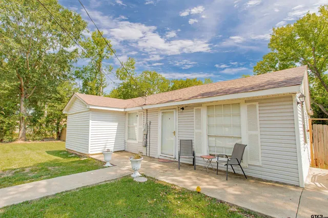 a view of a chair and table in backyard of the house