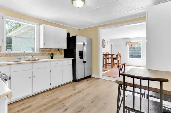 a kitchen with a table chairs refrigerator and window