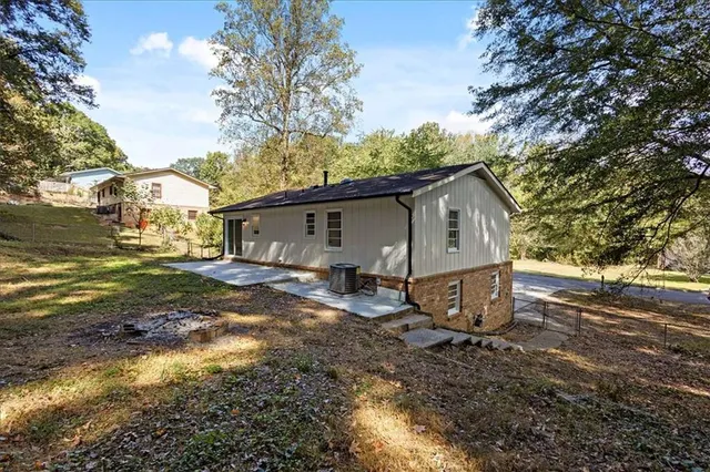 a view of a house with backyard and trees