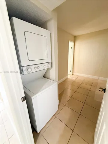 a view of a utility room with cabinet and mirror