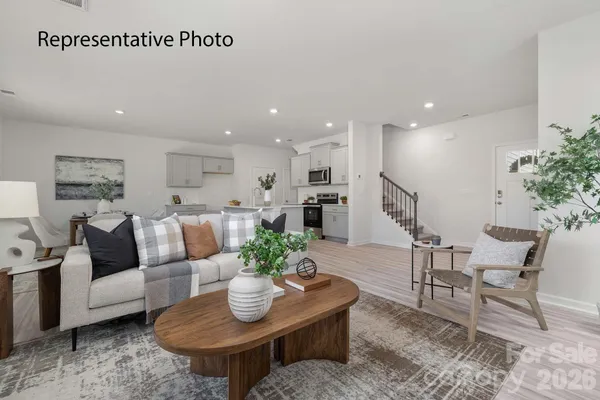 a living room with furniture kitchen and a potted plant