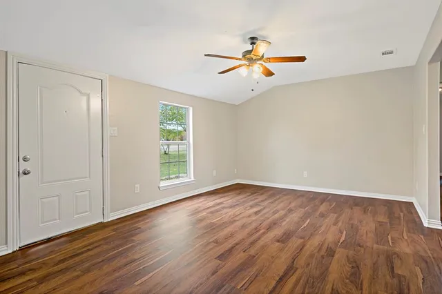 wooden floor in an empty room with a window