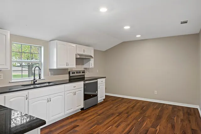 a kitchen with a sink window and cabinets