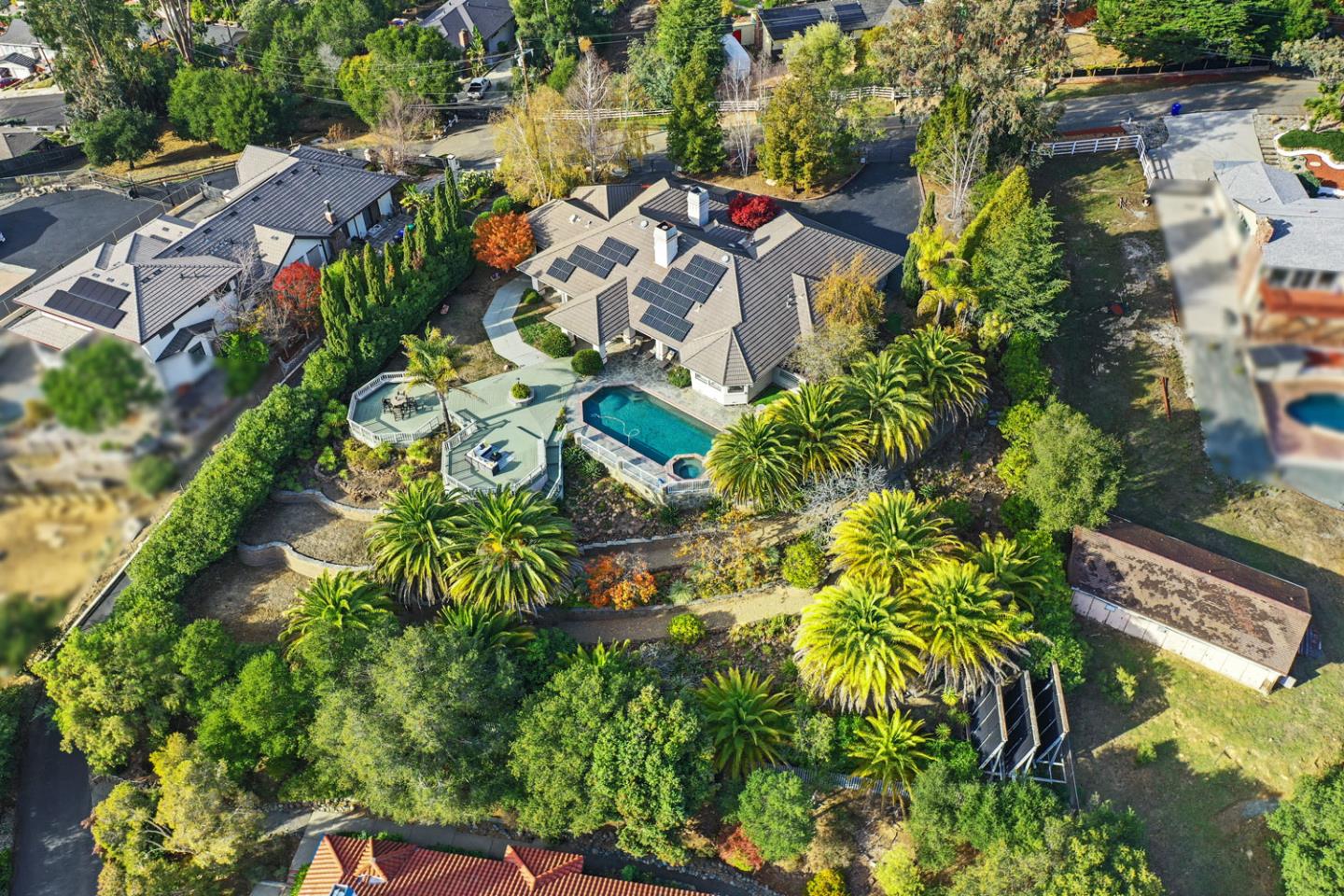 an aerial view of residential house with outdoor space and trees all around