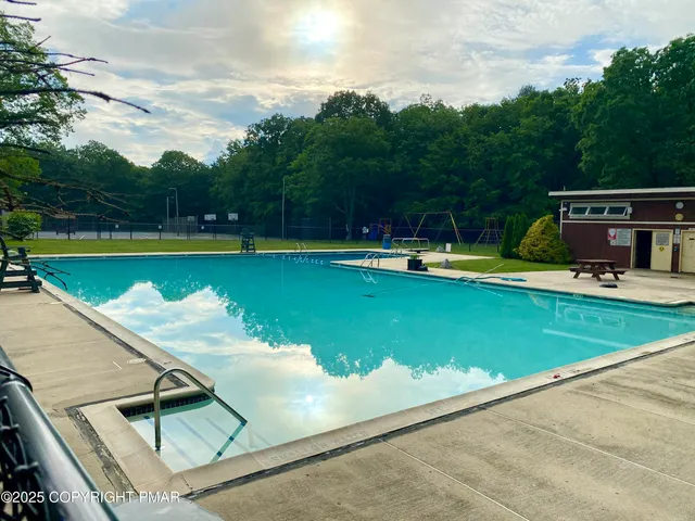 a view of a swimming pool with a yard and sitting area