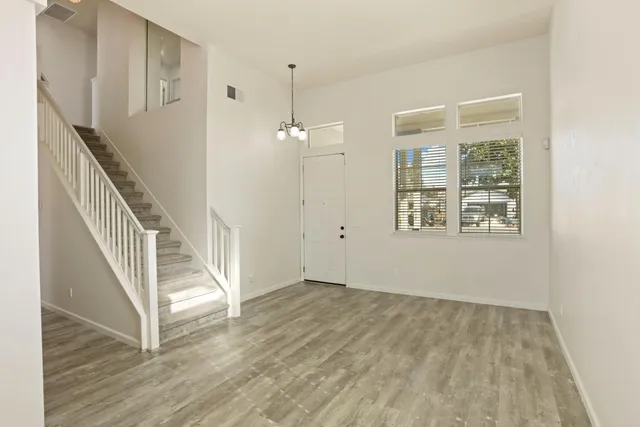wooden floor in a hall with an entryway and a window