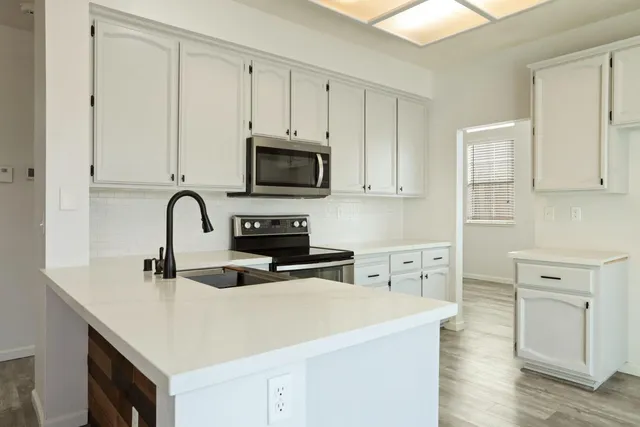 a kitchen with appliances a sink and cabinets