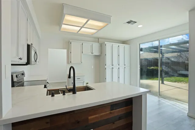 a kitchen with kitchen island a sink appliances and a counter top space