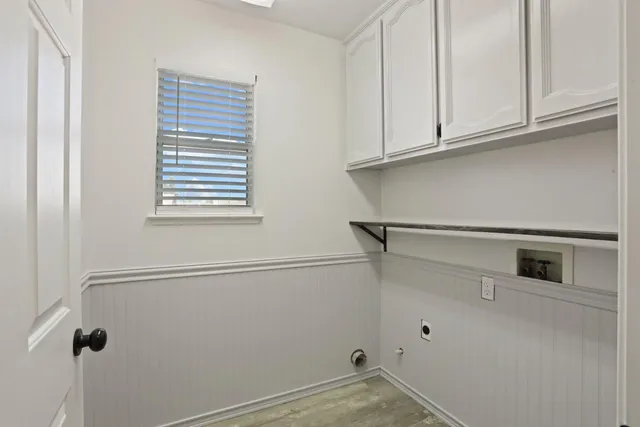 a view of a kitchen with white cabinets and a window