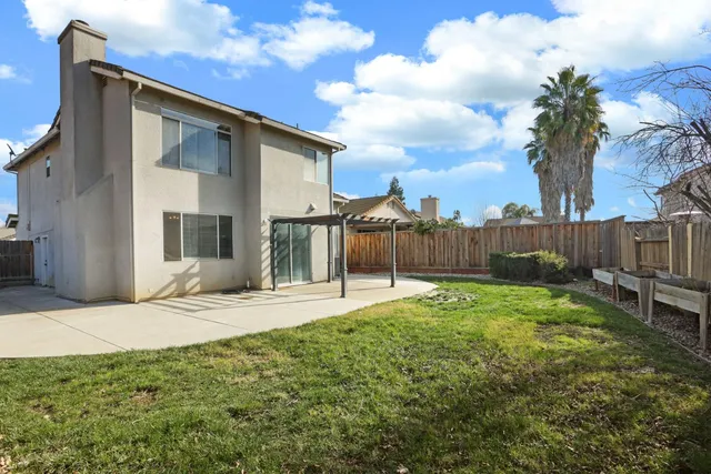 a backyard of a house with table and chairs
