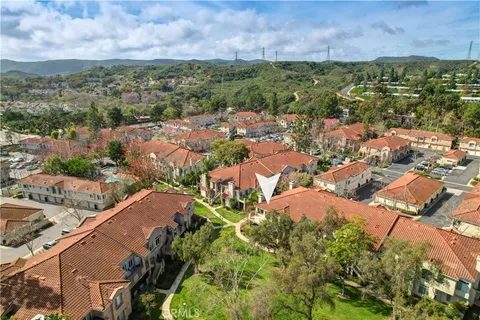 an aerial view of residential houses with outdoor space and trees