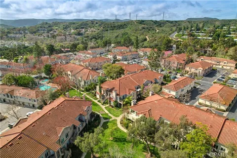 an aerial view of residential houses with outdoor space and trees