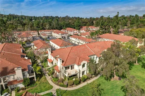 an aerial view of residential houses with outdoor space and trees