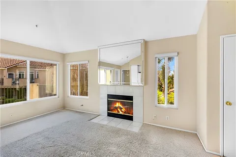 an empty room with windows and fireplace