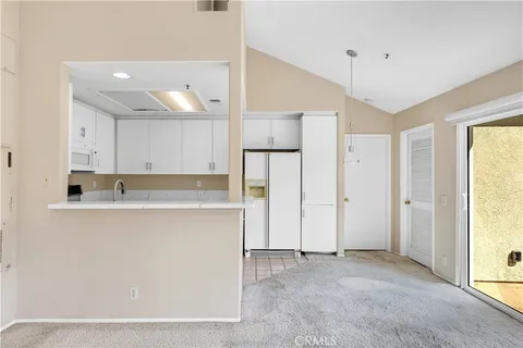 a view of kitchen with stainless steel appliances granite countertop a refrigerator and a sink