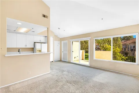 a large white kitchen with granite countertop a large window