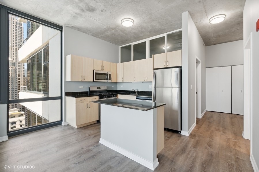 235 West Van Buren Street, Unit 3314 Chicago, IL 60607 - Photo 12 of 29 a kitchen with stainless steel appliances a refrigerator and a stove top oven