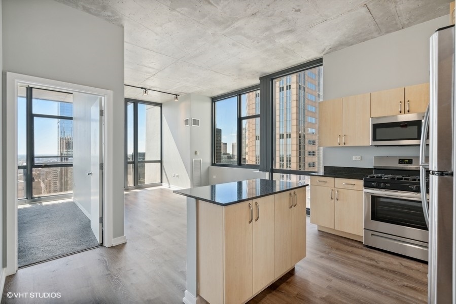235 West Van Buren Street, Unit 3314 Chicago, IL 60607 - Photo 13 of 29 a large kitchen with stainless steel appliances granite countertop a stove and a refrigerator