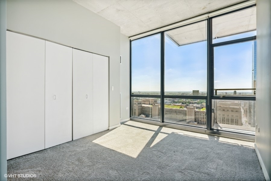 235 West Van Buren Street, Unit 3314 Chicago, IL 60607 - Photo 14 of 29 an empty room with sliding glass door and glass door