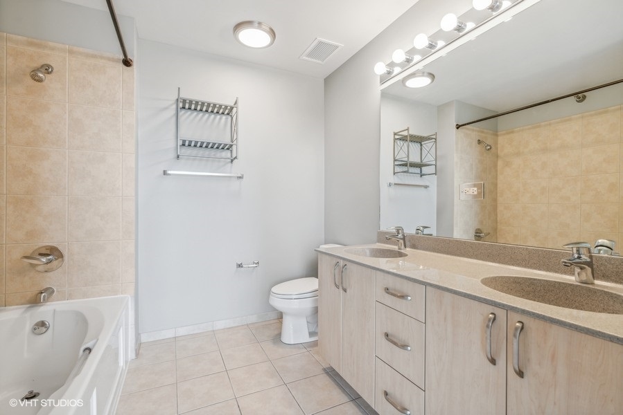 235 West Van Buren Street, Unit 3314 Chicago, IL 60607 - Photo 16 of 29 a bathroom with a toilet a sink a mirror a bathtub and shower