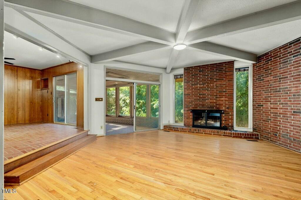 3237 Birnamwood Road Raleigh, NC 27607 - Photo 7 of 32 a view of an empty room with a fireplace and a window