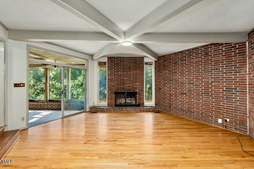 3237 Birnamwood Road Raleigh, NC 27607 - Photo 9 of 32 a view of a livingroom with wooden floor a fireplace and window
