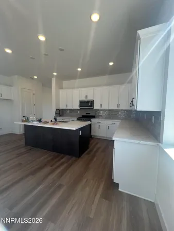 a kitchen with stainless steel appliances granite countertop a sink a stove a refrigerator and cabinets