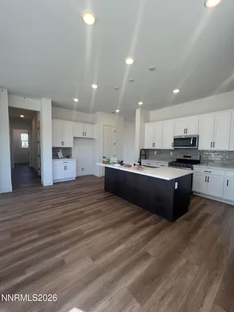 a large kitchen with kitchen island a sink stainless steel appliances and cabinets
