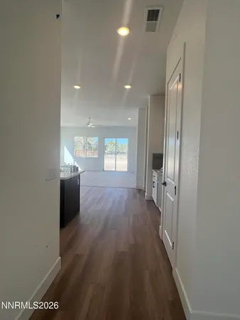 a view of a hallway with wooden floor and windows