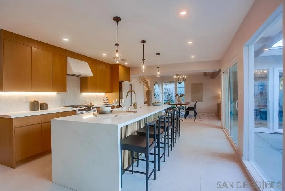 5878 Soledad Road La Jolla, CA 92037 - Photo 17 of 74 a kitchen with lots of counter space a sink appliances and a dining table
