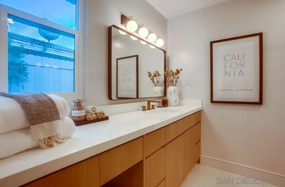 5878 Soledad Road La Jolla, CA 92037 - Photo 40 of 74 a bathroom with a double vanity sink and a mirror