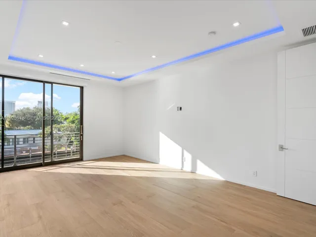 a view of a hallway with wooden floor and door