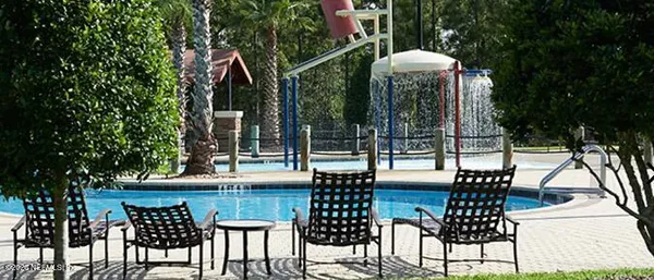 a view of balcony with table and chairs potted plants and large tree
