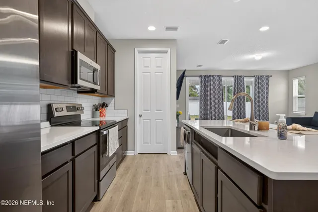 a kitchen with stainless steel appliances granite countertop a sink stove and refrigerator