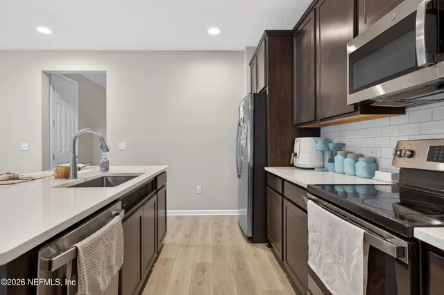 a kitchen with stainless steel appliances granite countertop a sink a stove and a refrigerator