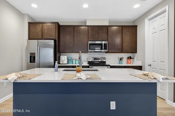 a large kitchen with kitchen island a sink stainless steel appliances and cabinets