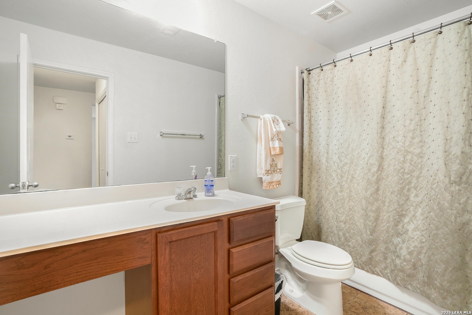 2306 Howry Drive Georgetown, TX 78626 - Photo 12 of 15 a bathroom with a sink a toilet a mirror and shower curtain
